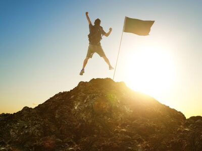 Man at the top of the mountain with a flag