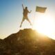 Man at the top of the mountain with a flag