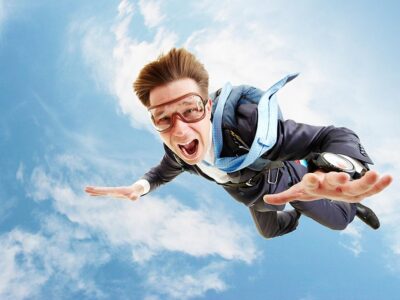 man with jumping with a parachute on his back